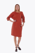 Raudona lininė suknelė ilgomis rankovėmis su kišenėmis, dėvima iš dviejų pusių